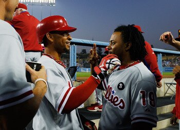 LOS ANGELES, CA - AUGUST 09:  Wilson Valdez #21 of the Philadelphia Phillies is congratulated by Michael Martinez #19 after scoring a run on a double by teammate Jimmy Rollins #11 against the Los Angeles Dodgers in the second inning of the baseball game a
