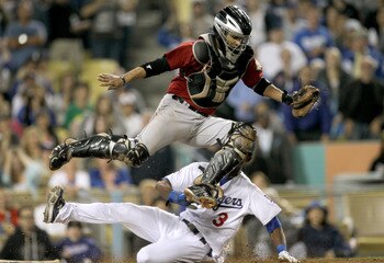 LOS ANGELES, CA - AUGUST 12: Catcher Carlos Corporan #22 of the Houston Astros jumps over pinch runner Eugenio Velez #3 of the Los Angeles Dodgers getting a force out for the second out of the ninth inning on August 12, 2011 at Dodger Stadium in Los Angel