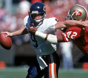 SAN FRANCISCO - OCTOBER 13:  Quarterback Jim McMahon #9 of the Chicago Bears tries to break away from safety Ronnie Lott #42 of the San Francisco 49ers during a game at Candlestick Park on October 13, 1985 in San Francisco, California.  The Bears won 26-1