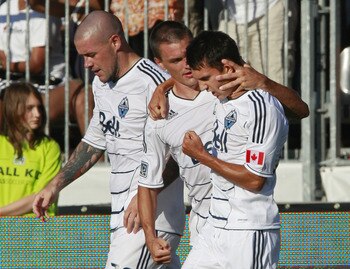 VANCOUVER, CANADA - AUGUST 27: Eric Hassli #29  (left) and Alain Rochat #4 celebrate with goal scorer Shea Salinas #22 of the Vancouver Whitecaps FC during their MLS game August 27, 2011 at Empire Field in Vancouver, British Columbia, Canada. Vancouver wo