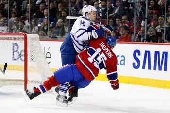 MONTREAL, CANADA - FEBRUARY 24:  Mikhail Grabovski #84 of the Toronto Maple Leafs body checks Jeff Halpern #15 of the Montreal Canadiens during the NHL game at the Bell Centre on February 24, 2011 in Montreal, Quebec, Canada.  (Photo by Richard Wolowicz/G