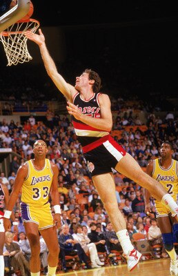 LOS ANGELES - DECEMBER 1987:  Kiki Vandeweghe #55 of the Portland Trail Blazers shoots a layup against Kareem Abdul-Jabbar #33 and Earvin 'Magic' Johnson #32 of the Los Angeles Lakers during a December 1987-1988 NBA season game at the Great Western Forum 