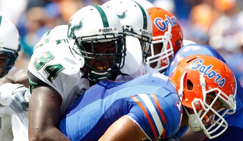 GAINESVILLE, FL - SEPTEMBER 11:  Quarterback Trey Burton #13 of the Florida Gators is tackled by Devekeyan Lattimore #34 of the South Florida Bulls  during a game at Ben Hill Griffin Stadium on September 11, 2010 in Gainesville, Florida.  (Photo by Sam Gr