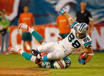 MIAMI GARDENS, FL - AUGUST 19:  Greg Olsen #88 of the Carolina Panthers is tackled by Karlos Dansby #58 of the Miami Dolphins during a Preseason NFL game  at Sun Life Stadium on August 19, 2011 in Miami Gardens, Florida.  (Photo by Mike Ehrmann/Getty Imag