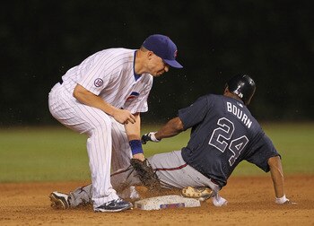 CHICAGO, IL - AUGUST 23: Michael Bourn #24 of the Atlanta Braves steals second base as Jeff Baker #28 of the Chicago Cubs applies the late tag at Wrigley Field on August 23, 2011 in Chicago, Illinois. (Photo by Jonathan Daniel/Getty Images)