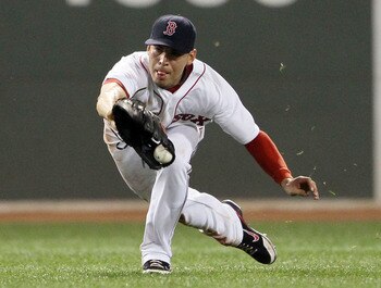 BOSTON, MA - JULY 23:  Jacoby Ellsbury #2 of the Boston Red Sox dives for a hit by Miguel Olivo #30 of the Seattle Mariners but drops it in the ninth inning on July 23, 2011 at Fenway Park in Boston, Massachusetts. The Boston Red Sox defeated the Seattle