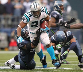 SEATTLE, WA - DECEMBER 05:  Running back Jonathan Stewart #28 of the Carolina Panthers rushes against Junior Siavii #94 (L) and Earl Thomas #29 of the Seattle Seahawks at Qwest Field on December 5, 2010 in Seattle, Washington. The Seahawks defeated the Pa