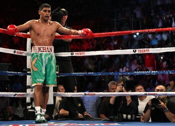 LAS VEGAS, NV - JULY 23:  Amir Khan stands in his corner as Zab Judah lays on the mat as referee Vic Drakulich calls the fight in the fifth round in their super lightweight world championship unification bout at Mandalay Bay Events Center on July 23, 2011