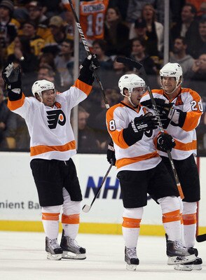 BOSTON, MA - DECEMBER 11:  Mike Richards #18 of the Philadelphia Flyers is congratulated by teammates Chris Pronger #20 and Kimmo Timonen #44 after Richards scored the game winning goal in overtime against the Boston Bruins on December 11, 2010 at the TD 