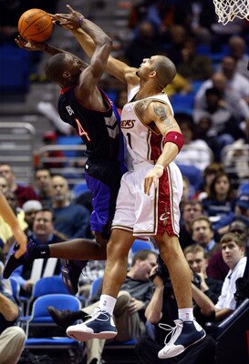 CLEVELAND - DECEMBER 9:  Carlos Boozer #1 of the Cleveland Cavaliers blocks a shot attempt by Chris Bosh #20 of the Toronto Raptors December 9, 2003 at Gund Arena in Cleveland, Ohio.  NOTE TO USER: User expressly acknowledges and agress that, by downloadi
