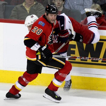CALGARY, AB - MARCH 4: Robyn Regehr #28 of the Calgary Flames upsets RJ Umberger #18 of the Columbus Blue Jackets in the third period of NHL action on March 4, 2011 at the Scotiabank Saddledome in Calgary, Alberta, Canada. (Photo by Mike Ridewood/Getty Im