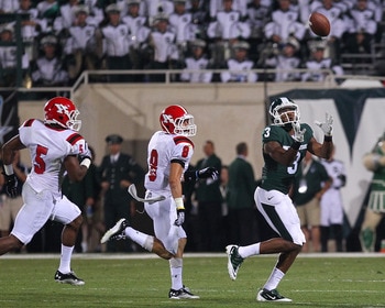 EAST LANSING, MI - SEPTEMBER 02:  B.J. Cunningham #3 of the Michigan State Spartans catches the ball against Donald D'Alesio #8 and Jeremy Edwards #5 of the Youngstown State Penguins during an NCAA football game at Spartan Stadium on September 2, 2011 in