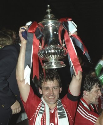 17 May 1990:  Bryan Robson of Manchester United holds the trophy aloft after their victory in the FA Cup final replay against Crystal Palace at Wembley Stadium in London. Manchester United won the match 1-0. \ Mandatory Credit: Ben  Radford/Allsport
