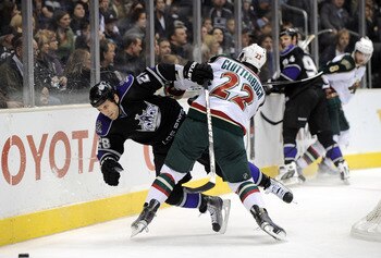 LOS ANGELES, CA - DECEMBER 11:  Jarret Stoll #28 of the Los Angeles Kings is knocked off his feet by Cal Clutterbuck #22 of the Minnesota Wild during the second period at the Staples Center on December 11, 2010 in Los Angeles, California.  (Photo by Harry