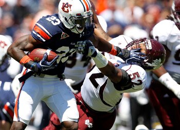 AUBURN, AL - SEPTEMBER 10:  Running back Onterio McCalebb #23 of the Auburn Tigers stiffarms linebacker Ferlando Bohanna #52 of the Mississippi State Bulldogs  in the second quarter on September 10, 2011 at Jordan-Hare Stadium in Auburn, Alabama. (Photo b