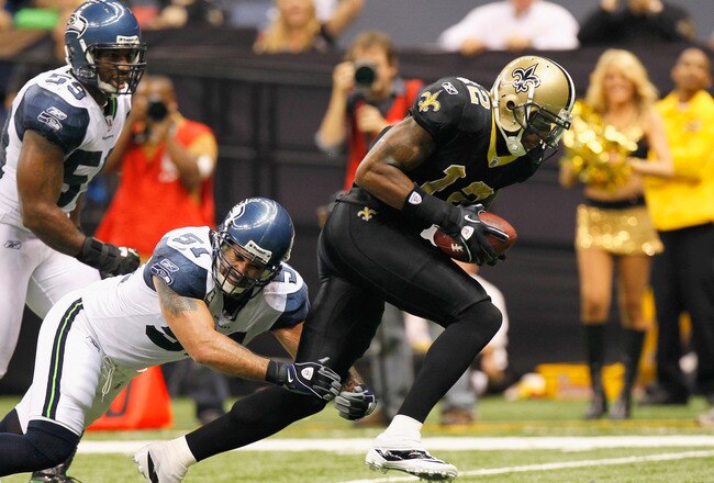 NEW ORLEANS - NOVEMBER 21:  Marques Colston #12 of the New Orleans Saints scores a touchdown as he breaks a tackle by Lofa Tatupu #51 of the Seattle Seahawks at Louisiana Superdome on November 21, 2010 in New Orleans, Louisiana.  (Photo by Kevin C. Cox/Ge