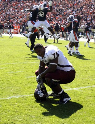 AUBURN, AL - SEPTEMBER 10:  Offensive lineman Blaine Clausell #75 of the Mississippi State Bulldogs reacts to the loss as defensive tackle Kenneth Carter #92 and defensive lineman Devaunte Sigler #96 of the Auburn Tigers celebrate a 41-34 win in the fourt