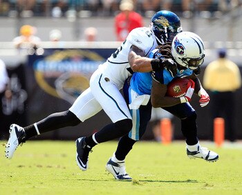 JACKSONVILLE, FL - SEPTEMBER 11:   Dawan Landry #26 of the Jacksonville Jaguars tackles  Chris Johnson #28 of the Tennessee Titans during the season opener game at EverBank Field on September 11, 2011 in Jacksonville, Florida.  (Photo by Sam Greenwood/Get