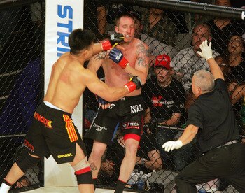Cung Le (left) delivers a blow to opponent Brian Warren during the StrikeForce mixed martial arts event at HP Pavilion on June 9, 2006 in San Jose, California. Le beat Warren via knockout to remain undefeated. (Photo by John Medina/Getty Images)