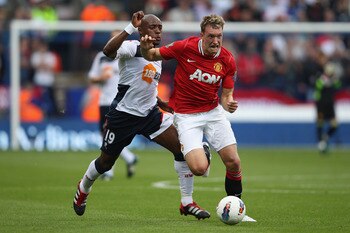 BOLTON, ENGLAND - SEPTEMBER 10: Phil Jones (R) of Manchester United tracked by Nigel Reo-Coker of Bolton Wanderers during the Barclays Premier League at the Reebok Stadium on September 10, 2011 in Bolton, England.  (Photo by Michael Steele/Getty Images)