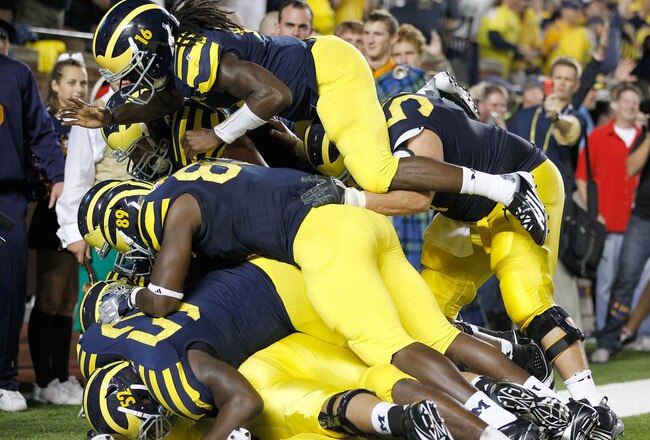 ANN ARBOR, MI - SEPTEMBER 10: Denard Robinson #16 of the Michigan Wolverines celebrates a Vincent Smith #2 fourth quarter touchdown with Brandon Moore #89, Ricky Barnum #52 and several other Wolverines while playing the Notre Dame Fighting Irish  at Michi