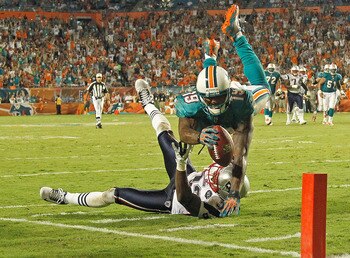 MIAMI GARDENS, FL - SEPTEMBER 12:  Brandon Marshall #19 of the Miami Dolphins scores a touchdown over  Devin McCourty #32 of the New England Patriots during a game  at Sun Life Stadium on September 12, 2011 in Miami Gardens, Florida.  (Photo by Mike Ehrma