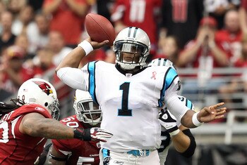 GLENDALE, AZ - SEPTEMBER 11:  Quarterback Cam Newton #1 of the Carolina Panthers throws a pass under pressure from Darnell Dockett #90 of the Arizona Cardinals during the NFL season opening game at the University of Phoenix Stadium on September 11, 2011 i