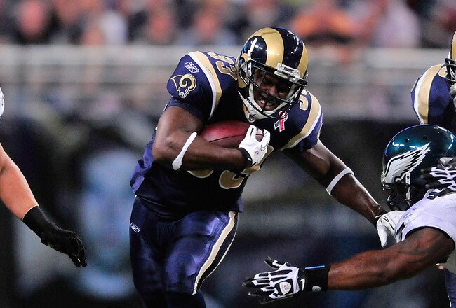 ST. LOUIS, MO - SEPTEMBER 11: Cadillac Williams #33 of the St. Louis Rams runs and pushes off of Cullen Jenkins #97 of the Philadelphia Eagles at the Edward Jones Dome on September 11, 2011 in St. Louis, Missouri. The Eagles defeated the Rams 31-15. (Phot