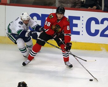 CHICAGO, IL - APRIL 17: Patrick Kane #88 of the Chicago Blackhawks looks to pass under pressure from Dan Hamhuis #2 of the Vancouver Canucks in Game Three of the Western Conference Quarterfinals during the 2011 NHL Stanley Cup Playoffs at the United Cente