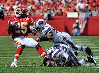 KANSAS CITY, MO - SEPTEMBER 11:  Defenders Aaron Williams #23 and Nick Barnett #50 of the Buffalo Bills tackle running back Jamaal Charles #25 of the Kansas City Chiefs after making a catch during the second quarter on September 11, 2011 at Arrowhead Stad