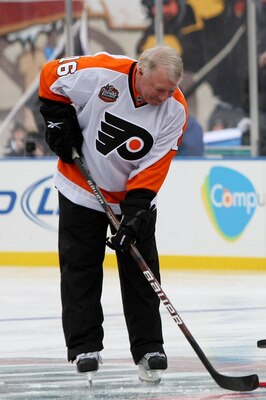 BOSTON - JANUARY 01:  Staff Sergeant Ryan R. LaFrance (C) drops the ceremonial first puck for Bobby Clarke #16 (L) honorary captain of the Philadelphia Flyers and Bobby Orr #4 (R) honorary captain of the Boston Bruins during the 2010 Bridgestone Winter Cl
