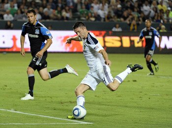CARSON, CA - AUGUST 20:  Robbie Keane #14 of the Los Angeles Galaxy scores a goal in his debut game in front of Bobby Burling #2 of the San Jose Earthquakes during the frist half at The Home Depot Center on August 20, 2011 in Carson, California.  (Photo b