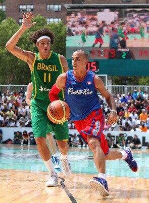 NEW YORK CITY, NY - AUGUST 13:  Carlos Arroyo of team Puerto Rico handles the ball against Anderson Varejao #11 of team Brazil during the World Basketball Festival at Rucker Park on August 13, 2010 in New York City.  (Photo by Marc Lecureuil/Getty Images