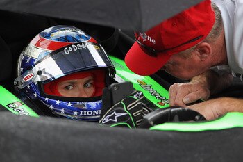 INDIANAPOLIS, IN - MAY 22:  Danica Patrick, driver of the #7 Team GoDaddy Dallara Honda, talks with Al Unser, Jr. as she waits in the rain while her car is covered as the next to qualify when the session was postponed due to rain during qualifying for the