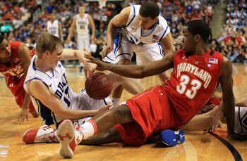 GREENSBORO, NC - MARCH 11:  Kyle Singler #12 of the Duke Blue Devils and Dino Gregory #33 of the Maryland Terrapins battle for possession of the ball during the second half in the quarterfinals of the 2011 ACC men's basketball tournament at the Greensboro