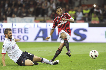 MILAN, ITALY - MAY 14:  Robinho (R) of Milan shoots at goal as he is challenged by Gabriele Perico of Cagliari during the Serie A match between AC Milan and Cagliari Calcio at Stadio Giuseppe Meazza on May 14, 2011 in Milan, Italy.  (Photo by Dino Panato/