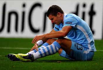 MANCHESTER, ENGLAND - SEPTEMBER 14:   Aleksandar Kolarov of Manchester City sits on the pitch after sustaining a facial injury during the UEFA Champions League Group A match between Manchester City and SSC Napoli at the Etihad Stadium on September 14, 201