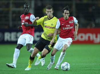 DORTMUND, GERMANY - SEPTEMBER 13:  Yossi Benayoun of Arsenal is tackled by Ivan Perisic of Borussia Dortmund during the UEFA Champions League Group F match between Borussia Dortmund and Arsenal FC at Signal Iduna Park on September 13, 2011 in Dortmund, Ge