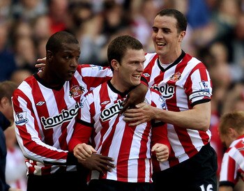 SUNDERLAND, ENGLAND - SEPTEMBER 18:  Titus Bramble (L) and John O'Shea (R) celebrate with Craig Gardner after he scored their third goal during the Barclays Premier League match between Sunderland and Stoke City at Stadium of Light on September 18, 2011 i
