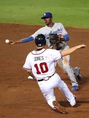 ATLANTA, GA - SEPTEMBER 02:  Shortstop Dee Gordon #9 of the Los Angeles Dodgers turns a double play while third baseman Chipper Jones #10 of the Atlanta Braves slids to try to break it up during the game at Turner Field on September 2, 2011 in Atlanta, Ge
