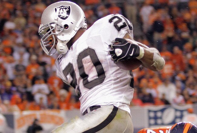 DENVER, CO - SEPTEMBER 12:   Darren McFadden #20 of the Oakland Raiders is tackled by Champ Bailey #24 of the Denver Broncos at the one yard line after rushing for 47 yards to set up a fourth quarter touchdown at Sports Authority Field at Mile High on Sep