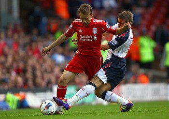 LIVERPOOL, ENGLAND - AUGUST 27:  Leiva Lucas of Liverpool is tackled by Ivan Klasnic of Bolton Wanderers looks on during the Barclays Premier League match between Liverpool and Bolton Wanderers at Anfield on August 27, 2011 in Liverpool, England.  (Photo
