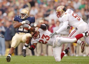 SOUTH BEND, IN - NOVEMBER 1:  Running back Julius Jones #22 of Notre Dame is stopped by cornerback Jerome Carter and linebacker Michael Boulware #58 of Florida State during a game on November 1, 2003 at the Notre Dame Stadium in South Bend, Indiana. (Phot