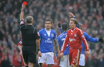 LIVERPOOL, ENGLAND - FEBRUARY 06:  Referee Martin Atkinson shows a red card to Steven Pienaar of Everton during the Barclays Premier League match between Liverpool and Everton at Anfield on February 6, 2010 in Liverpool, England.  (Photo by Laurence Griff