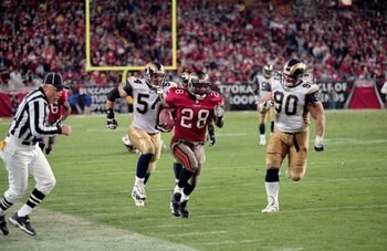 18 Dec 2000: Warrick Dunn #28 of the Tampa Bay Buccaneers carries the ball to make a touchdown as he is chased by Jeff Zgonina #90 and Todd Collins #54 of the St Louis Rams at the Raymond James Stadium in Tampa, Florida.  The Buccaneers defeated the Rams