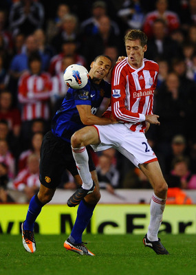 STOKE ON TRENT, ENGLAND - SEPTEMBER 24:  Rio Ferdinand of Manchester United and Peter Crouch of Stoke City battle for the ball during the Barclays Premier League match between Stoke City and Manchester United at the Britannia Stadium on September 24, 2011