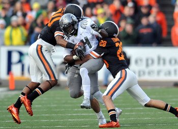 Two Beavers converge to stop Kenjon Barner in the 2010 Civil War