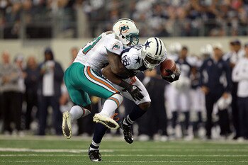 ARLINGTON, TX - NOVEMBER 24:   Dez Bryant #88 of the Dallas Cowboys is tackled by Vontae Davis #21 of the Miami Dolphins during the Thanksgiving Day game at Cowboys Stadium on November 24, 2011 in Arlington, Texas.  (Photo by Ronald Martinez/Getty Images)