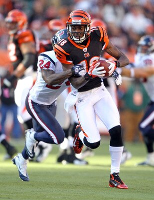 CINCINNATI, OH - DECEMBER 11:  A.J. Green #18 of the Cincinnati Bengals runs with the ball while defended by Brandon Harris #26 of the Houston Texans during the NFL game at Paul Brown Stadium on December 11, 2011 in Cincinnati, Ohio.  (Photo by Andy Lyons