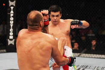 Lyoto Machida (R) connects with a kick against Randy Couture - Al Bello/Zuffa, LLC